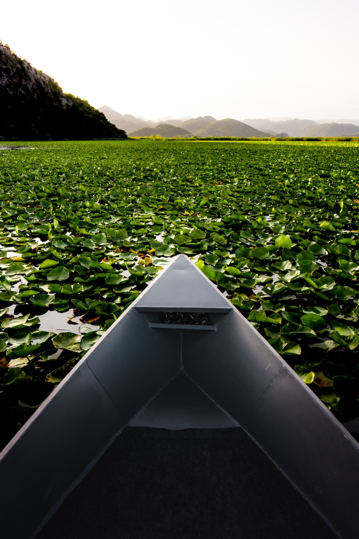 Canoe moving across water in a landscape photograph