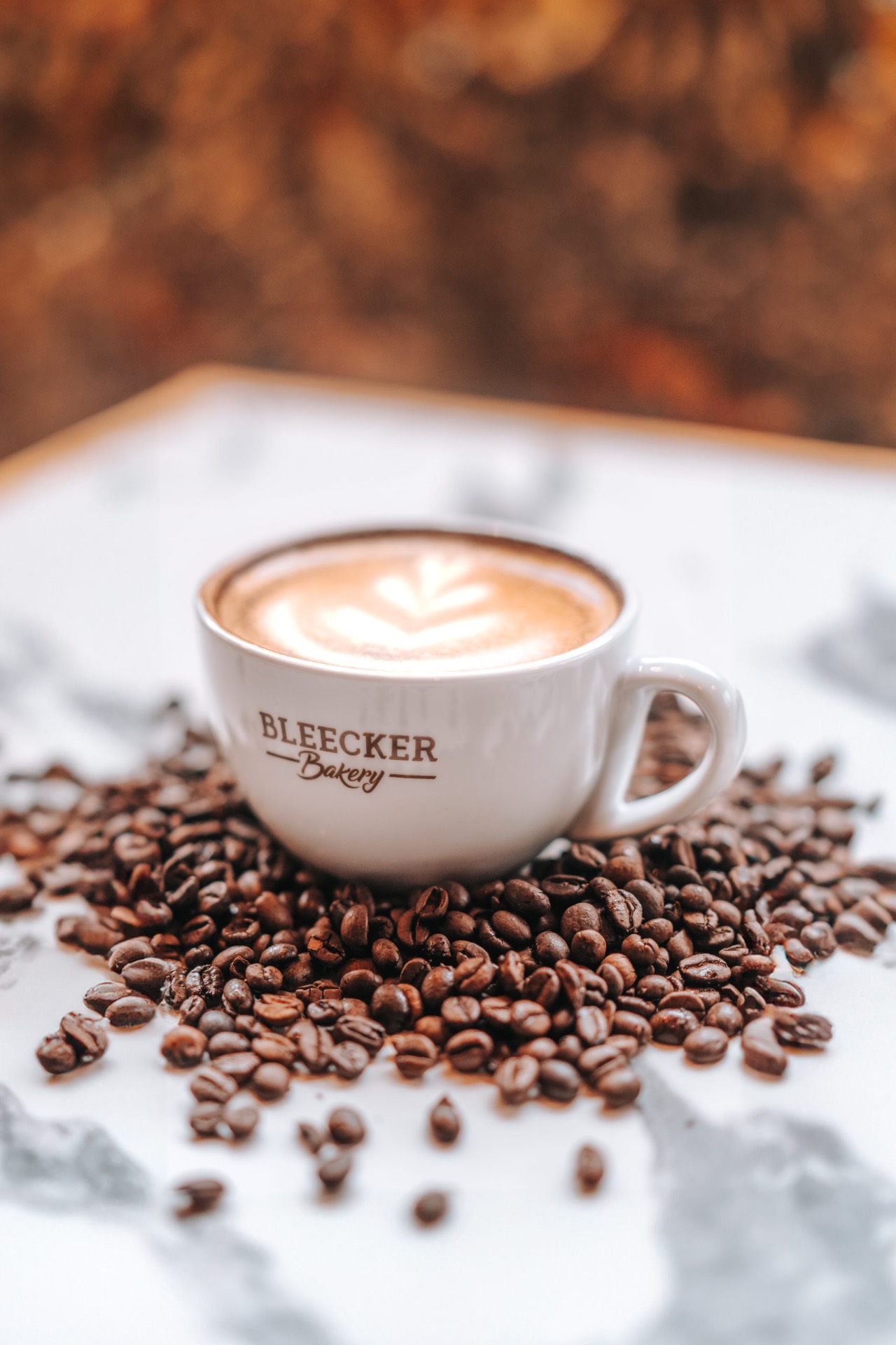 Coffee cup surrounded by roasted beans